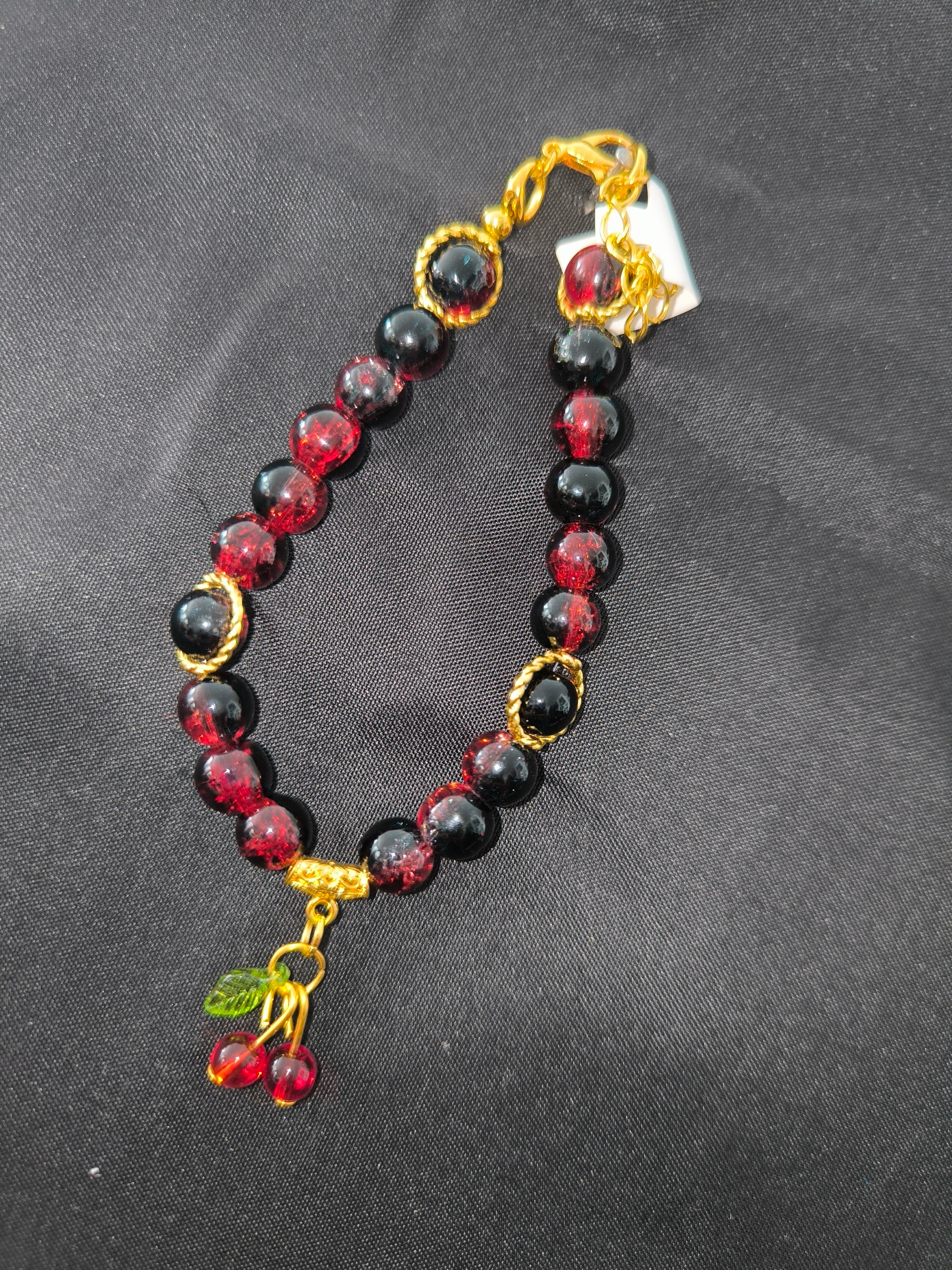 Bracelet artisanal perles de verre noir & rouge – Pampille cerises & acier doré | Les Créas de Steffy