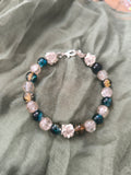 Bracelet rigide en perles en verre et fleur en acier inoxydable argenté